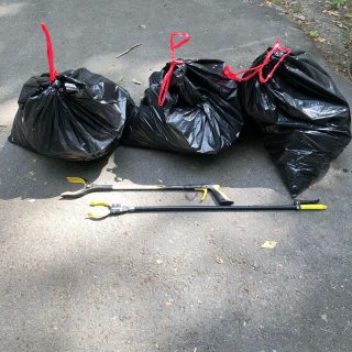 Three trash bags and trash collecting tools.