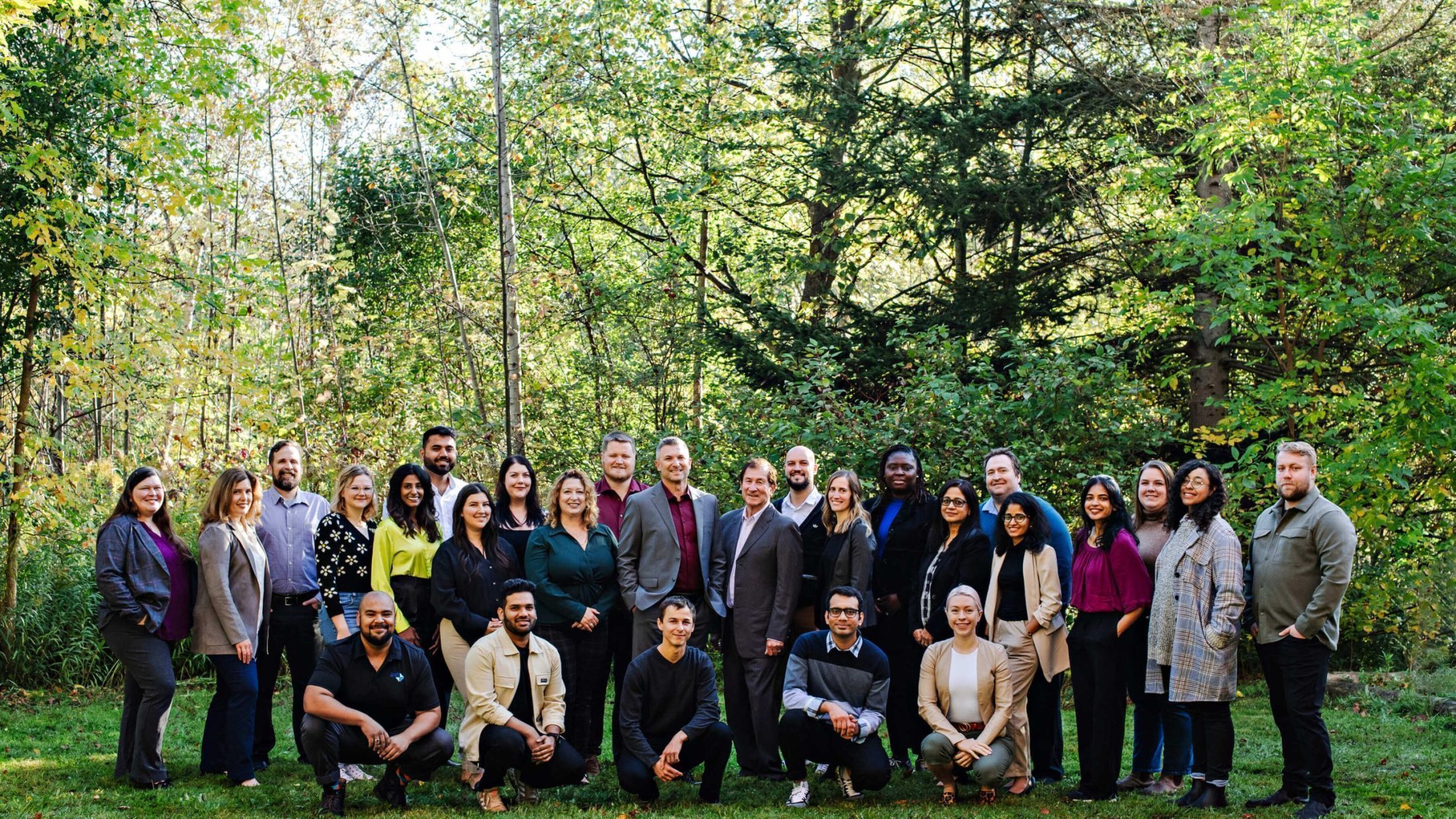 Photo of AET Employees in front of a park background
